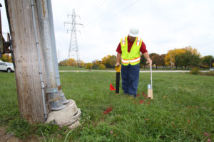 Technician walking through field with tools.