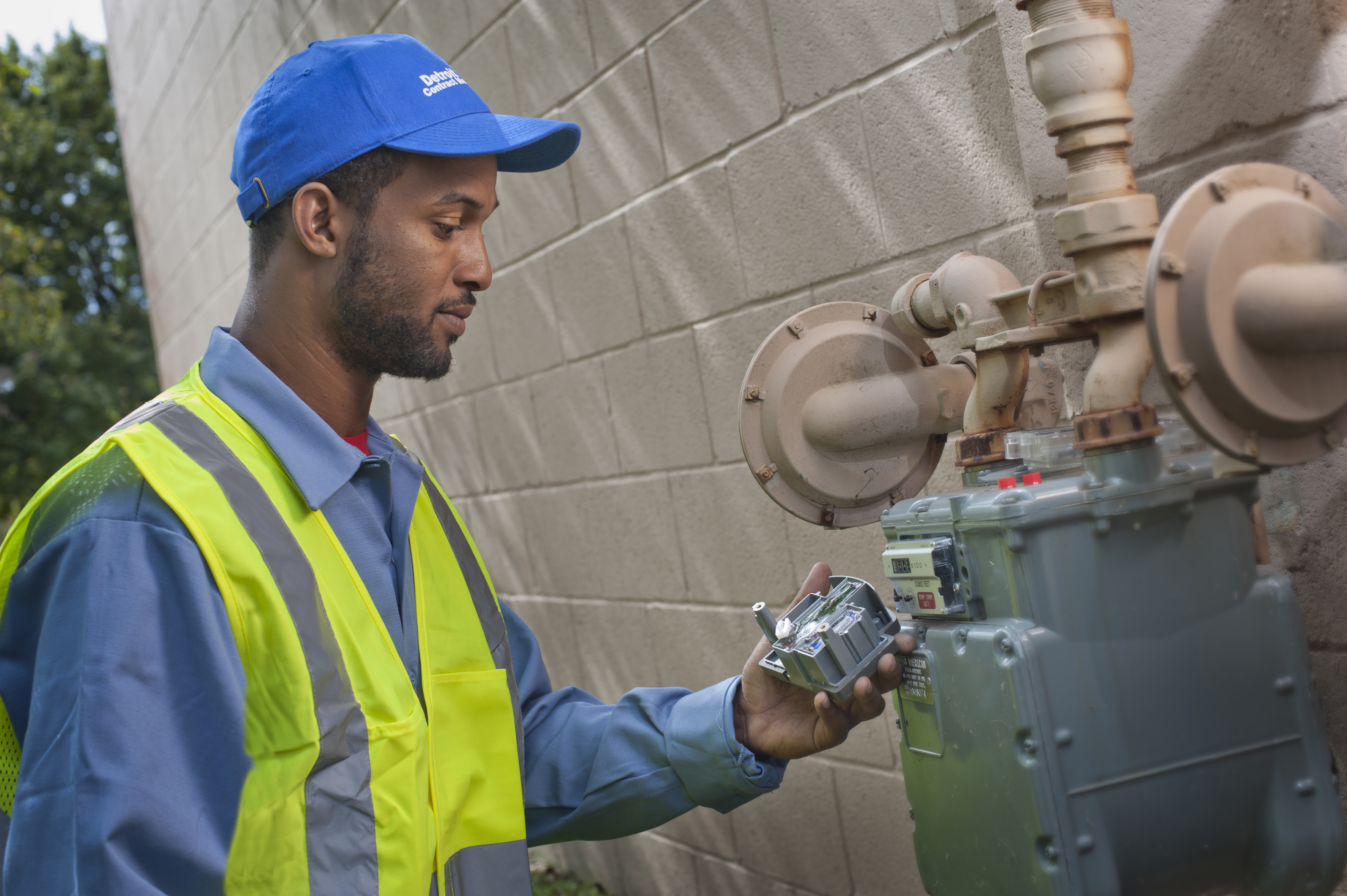 Technician manually testing water readings beside indoor pipes.